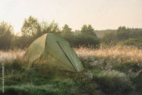 Tourist tent on the background of nature at sunrise.