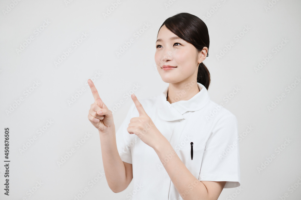 指さしのポーズをする白衣の女性 指さしのポーズをする白衣の女性