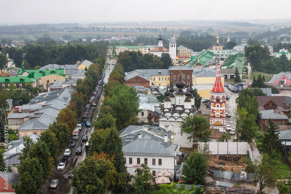 panoramic top view of the old town with historical architecture among the green foliage of trees and a cloudy summer day in Suzdal Russia