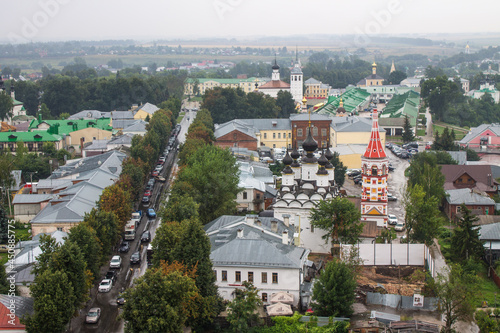 panoramic top view of the old town with historical architecture among the green foliage of trees and a cloudy summer day in Suzdal Russia © Inna