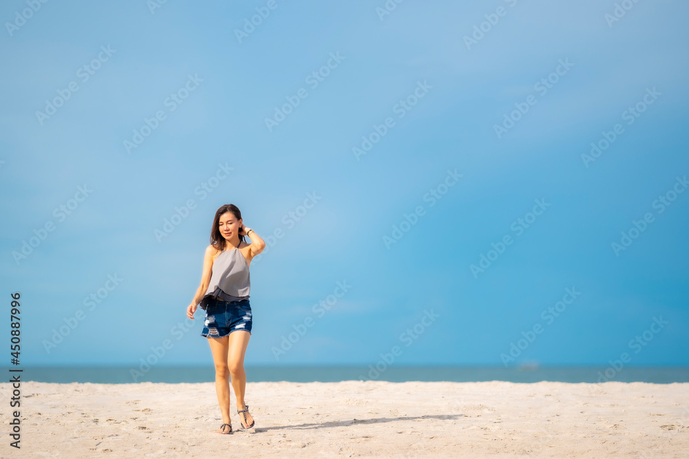 Portrait beautiful Asian woman walking at tropical beach and blue sky Portrait beautiful Asian woman walking at tropical beach and blue sky