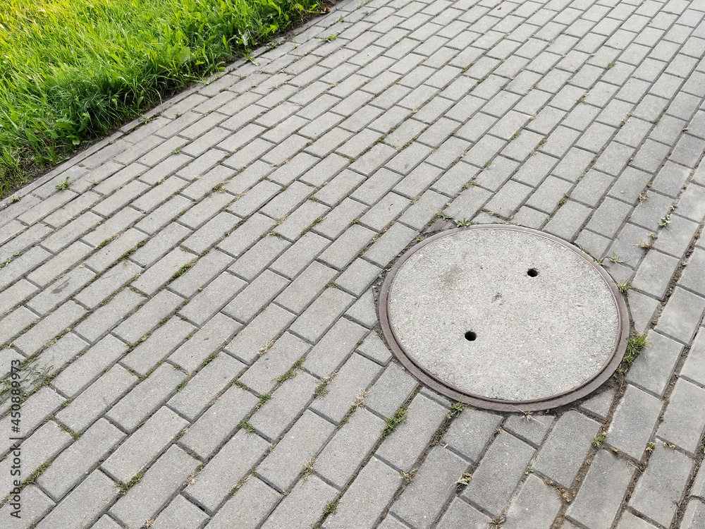 Sewage gully located on the pavement Sewage gully located on the pavement