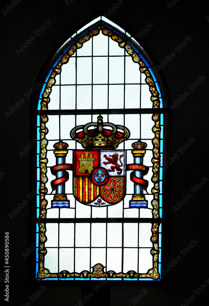 Vidriera en una ventana de arco apuntado con el Escudo Constitucional de España