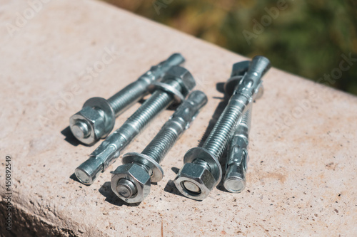 Concrete anchor screws for fixing metal structures isolated group in the concrete wall photo