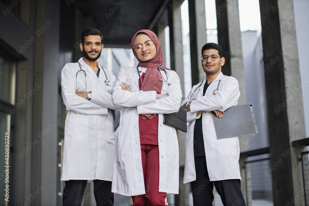 Foto De Front View Of High skilled Team Of Three Young Confident Saudi foto-de-front-view-of-high-skilled-team-of-three-young-confident-saudi