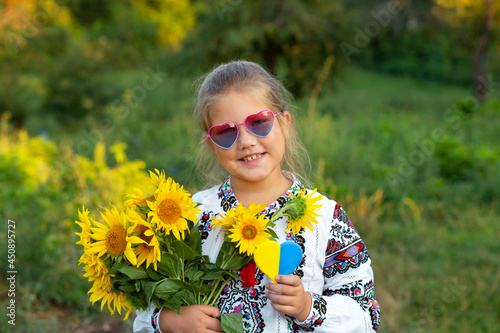 Yellow blue heart in hands of child dressed embroidered shirt. Ukraine Independence Day  flag  constitution concept. Selective focus. Nature.