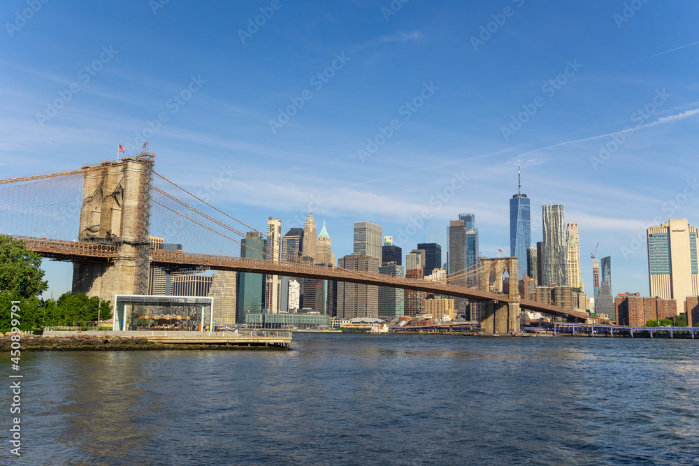 Cityscape of Brooklyn Bridge and Lower Manhattan skyscraper from beach of Brooklyn Bridge Park on June 18, 2021 in Brooklyn New York City.