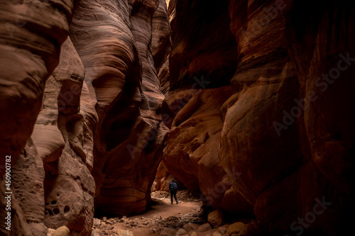 Hiker Passing Through The Imposing Rocks Of Buckskin Gulch