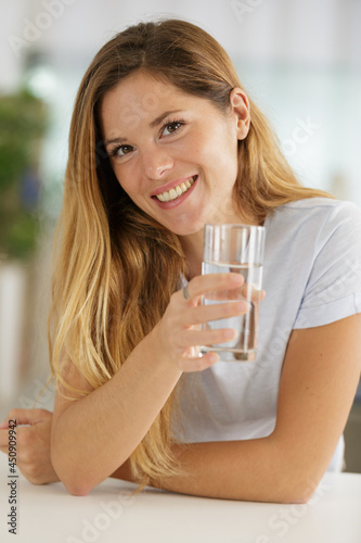 young woman with glass of water indoors