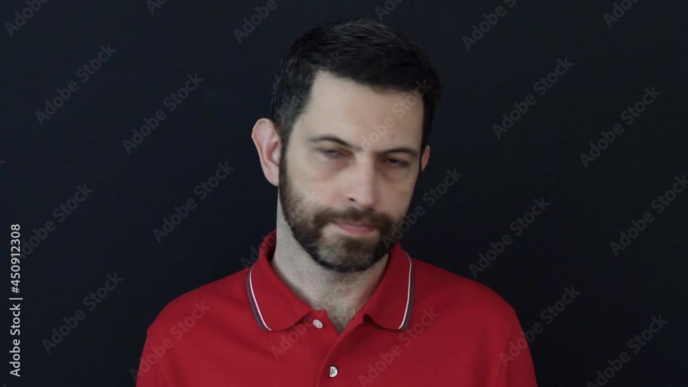 Man thinking to get happy news but disappointed afterwards. Fake news. 30s year old wearing a red t-shirt posing isolated on black color background in studio. Misunderstanding and communication failur Man thinking to get happy news but disappointed afterwards. Fake news. 30s year old wearing a red t-shirt posing isolated on black color background in studio. Misunderstanding and communication failur