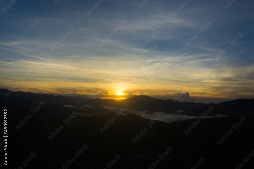 Scenic view of a sunrise over foggy mountain range
