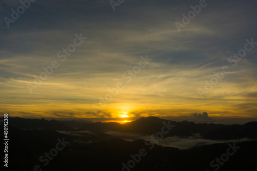 Scenic view of a sunrise over foggy mountain range