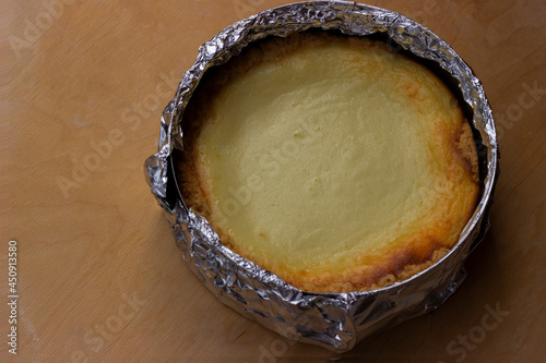 Freshly baked cheesecake on a wooden tray. Left copy space