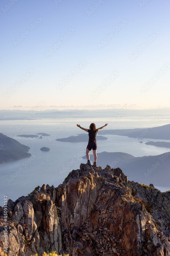 Adventurous Caucasian Woman Hiking on top of a Rocky Mountain Cliff. Sunny Summer Sunset. Mnt Brunswick Hike, North of Vancouver, British Columbia, Canada. Adventurous Caucasian Woman Hiking on top of a Rocky Mountain Cliff. Sunny Summer Sunset. Mnt Brunswick Hike, North of Vancouver, British Columbia, Canada.