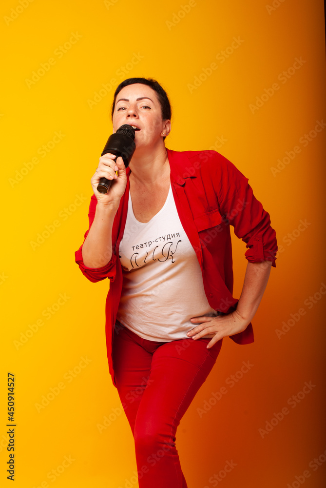 Woman with a microphone on a yellow background. The singer sings, Vocal lessons at school. The teacher is teaching. Woman with a microphone on a yellow background. The singer sings, Vocal lessons at school. The teacher is teaching.