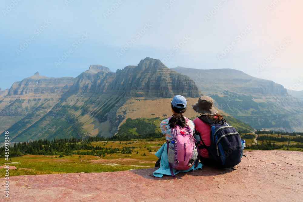 Fototapeta premium Hikers taking a break along the Logan Pass in Glacier National Park, Montana USA. Logan Pass is located along the Continental Divide in Glacier National Park.