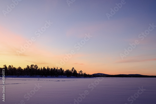 Sunset on a frozen lake in Finnish Lapland