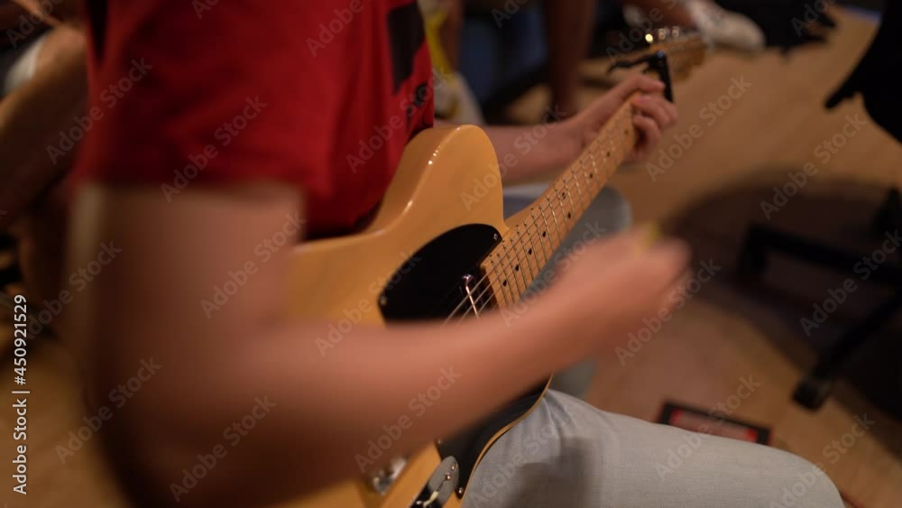 Plano cerrado de musico tocando guitarra eléctrica en un estudio de grabación 