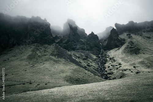 Dramatic foggy cliffs and stream in South Iceland