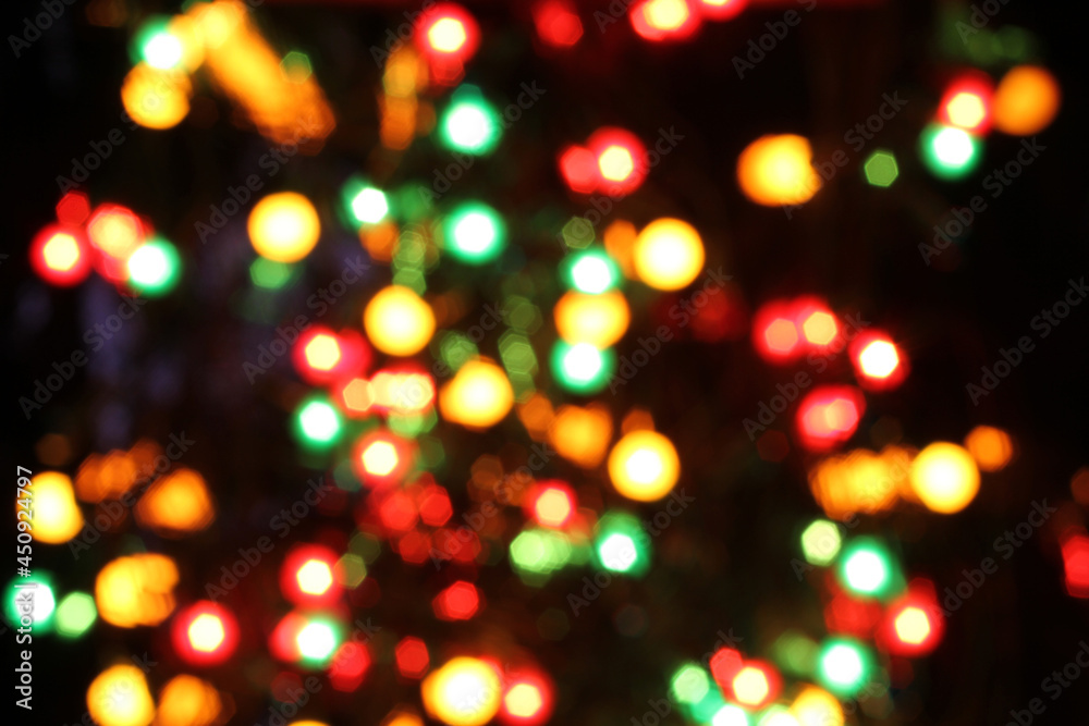 Blurred yellow, white, red, green and blue lights on black background