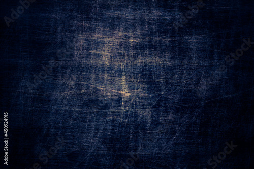 Dark blue ink toned pinewood scratched background with black and yellow elements, close up