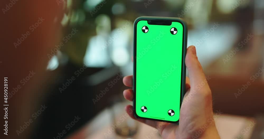 Hands holding smartphone with green screen. man having a video chat on a phone. Guy talking in online conference via internet in cafe 4k template footage