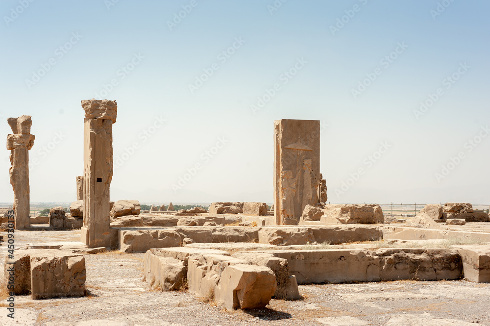 Fabulous view of ruins of the Hadish Palace (the Palace of Xerxes) on blue sky background in Persepolis, Iran. Ancient Persian city. Persepolis is a popular tourist destination of the Middle East.