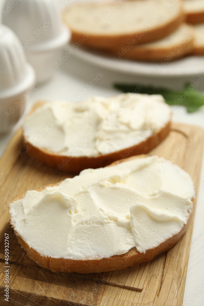 Bread with cream cheese on wooden table, closeup Bread with cream cheese on wooden table, closeup