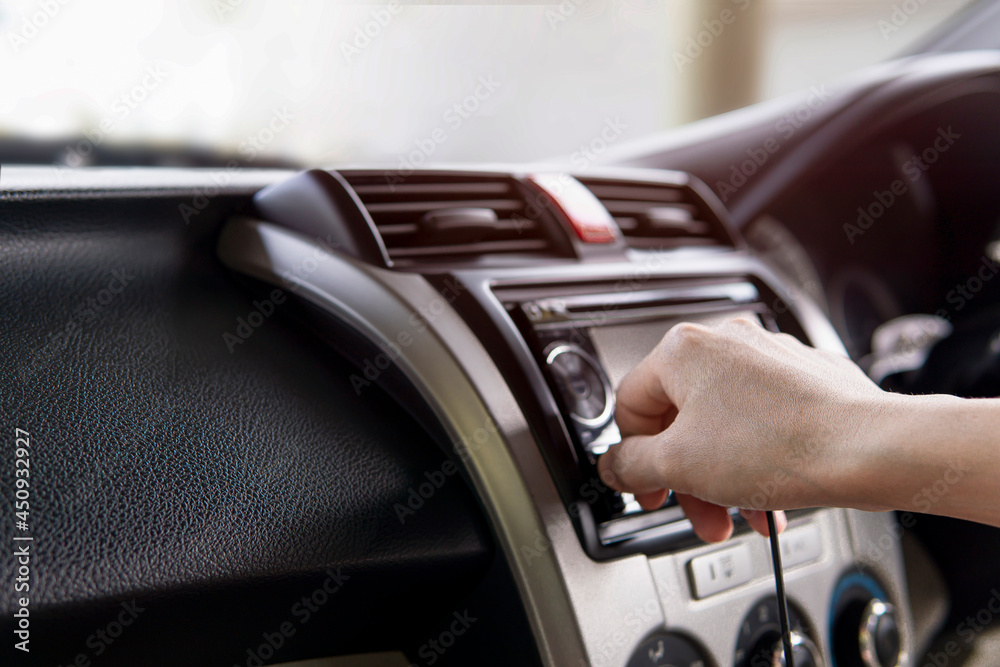 Hand a man plug in USB cable on the car audio use connecting data car play and music Navigation system in the car.