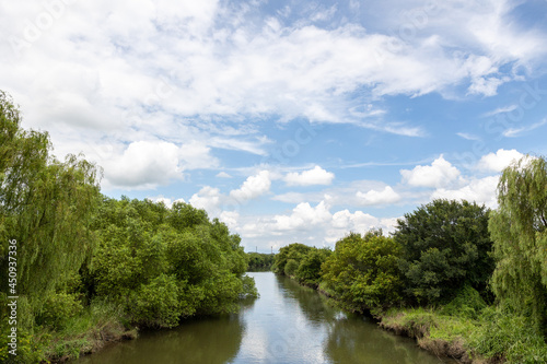 渡良瀬遊水地の近くに流れる谷田川と夏の青空
