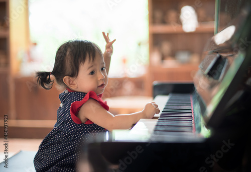 Little Asian cute girl playing piano