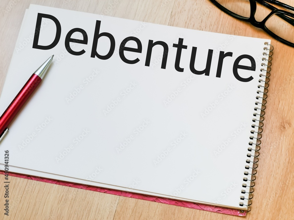 Text debenture written on note book with a pen and eye glasses. Text debenture written on note book with a pen and eye glasses.