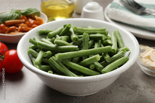 Fresh green beans and other ingredients for salad on grey table