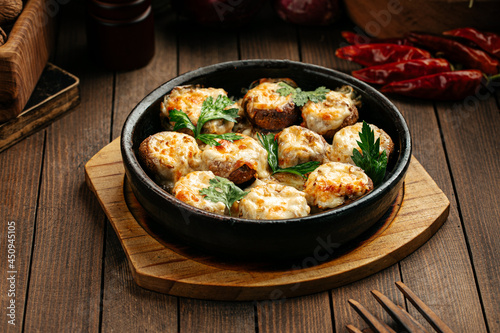 Georgian baked mushrooms with suluguni cheese on a wooden background