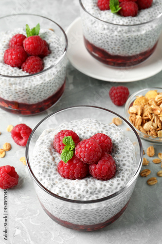 Delicious chia pudding with raspberries and mint on light marble table, above view