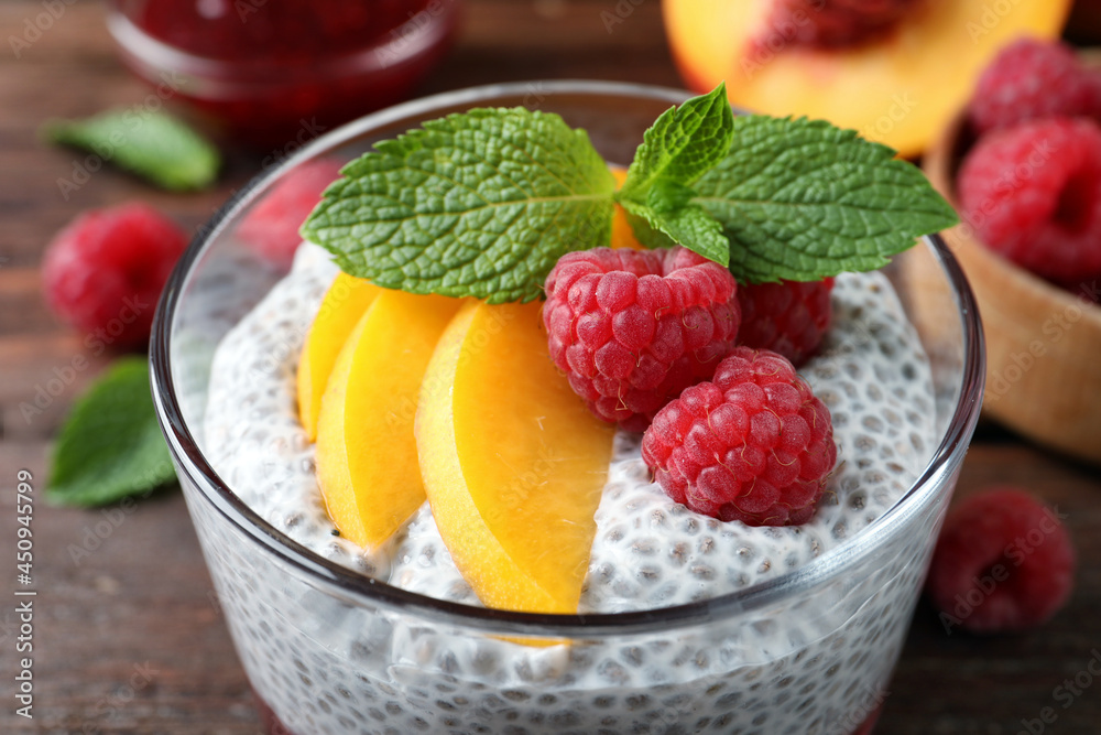 Delicious chia pudding with raspberries, peach and mint in glass, closeup Delicious chia pudding with raspberries, peach and mint in glass, closeup