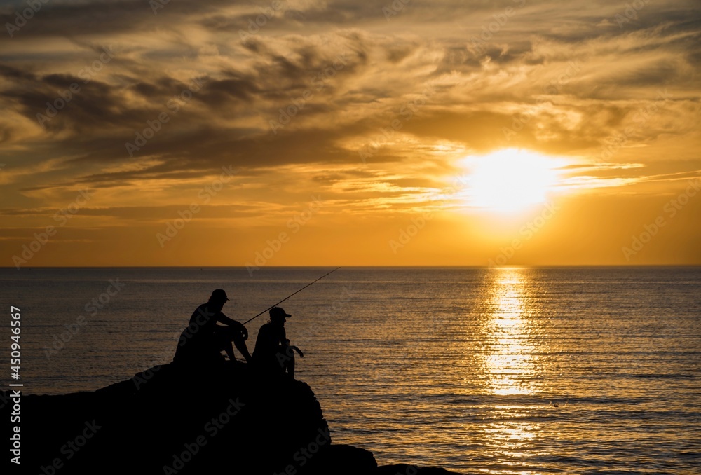 Silhouette of fishermen at sunset