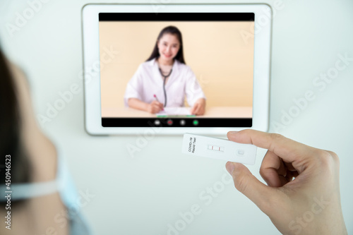 Asian woman having a consult with doctor via online video call.