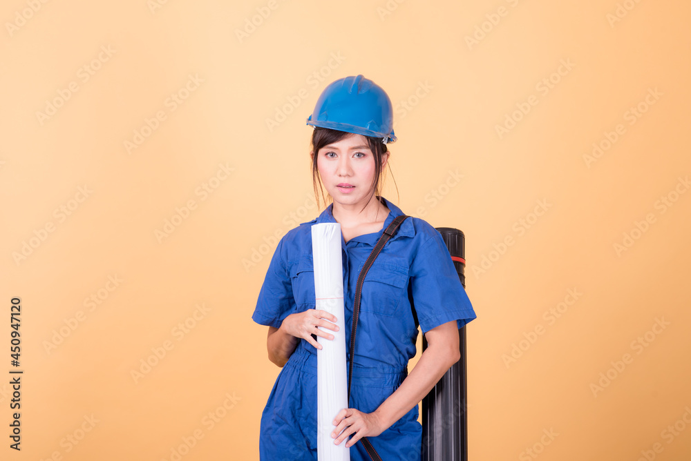 Young Asian female engineer working deliberately isolated on yellow background.