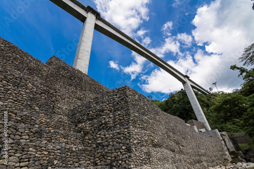 Looking up at Agas Agas bridge, the tallest bridge in the Philippines.Stone riprap abutment protects the foundation of the bridge. Located in Sogod, Leyte. photo