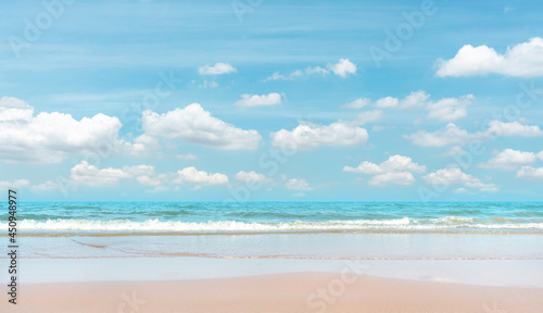 Sand beach on blue sea  white wave under white clouds  pastel blue sky