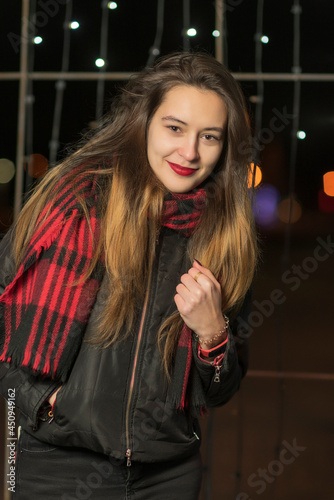 Portrait of a young beautiful dark-haired girl in the night city, close-up.