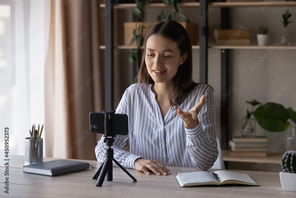 Smiling millennial Caucasian woman speaker or coach talk speak on video call on cellphone gadget. Happy young female trainer have webcam session or live broadcast shoot vlog on smartphone device.