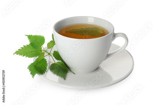 Cup of aromatic nettle tea and green leaves on white background