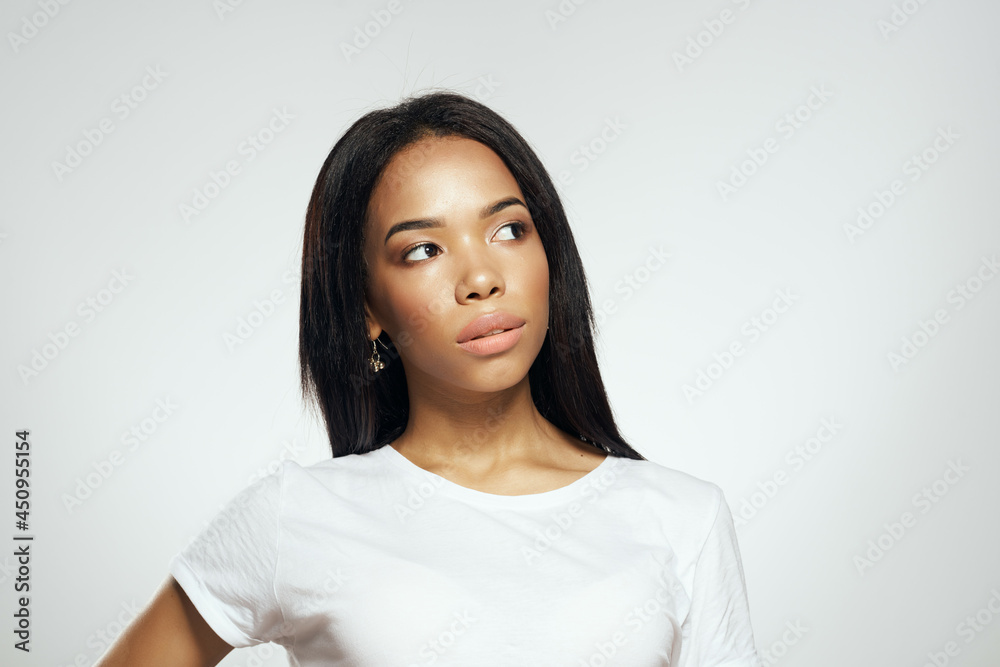 pretty woman of african appearance in t-shirt fashionable hairstyle light background pretty woman of african appearance in t-shirt fashionable hairstyle light background