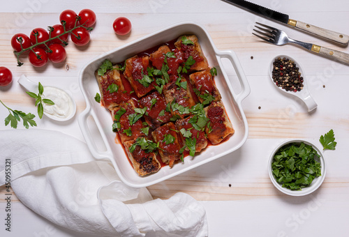 Flat lay with baked cabbage rolls in white square baking pan