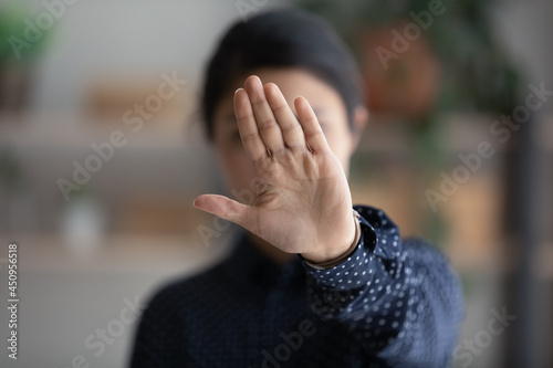 Close up of determined young Indian woman show stop no gesture protest against racial or gender discrimination. Serious ethnic biracial female make sign against abortion or domestic violence.