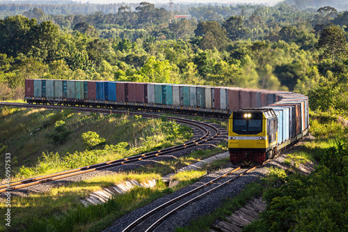 A freight train as it passes through the green fields.