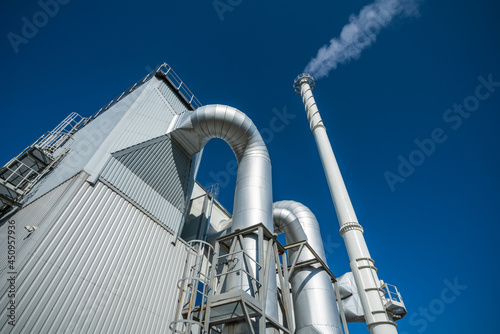 Biofuel boiler chimneys on a blue sky background.  Electrostatic precipitator in the foreground
 photo