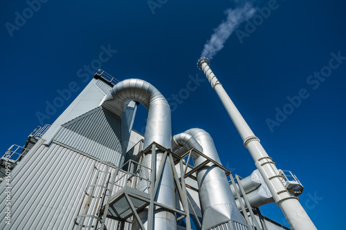 Biofuel boiler chimneys on a blue sky background.  Electrostatic precipitator in the foreground
 photo
